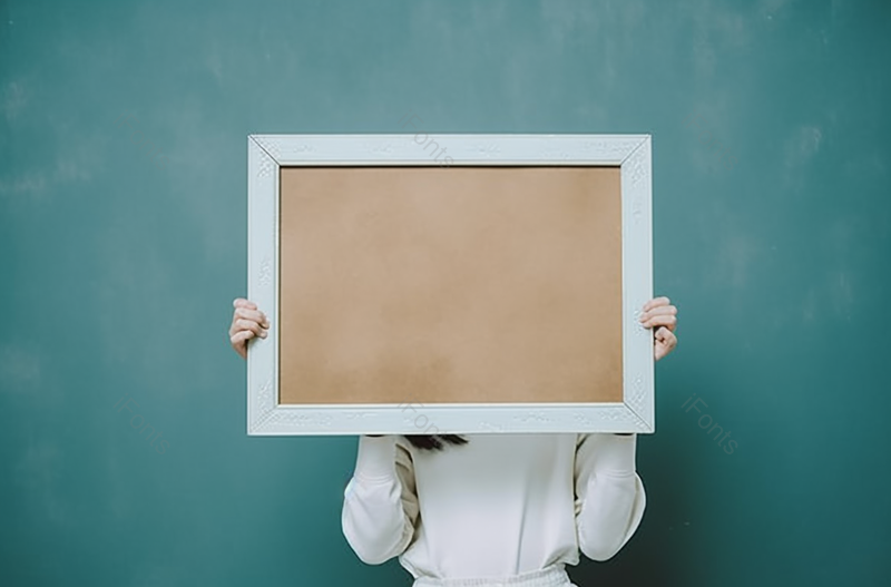 女孩持有一个空白框架在绿色背景上,高清,摄影图,摄影图片,图片大全,摄影图免费下载